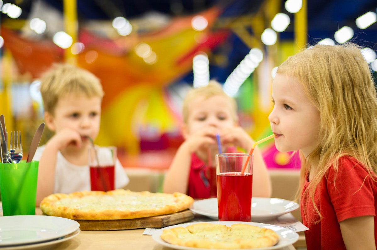 Enfants entrain de boire un sirop et de manger.