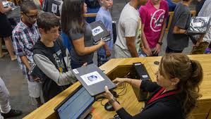 Staff member checks out Chromebooks to students.