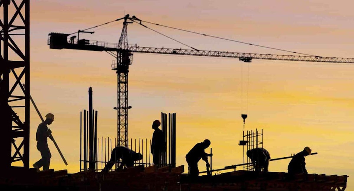 Construction workers silhouetted against sunset sky with crane - building high-performing field teams