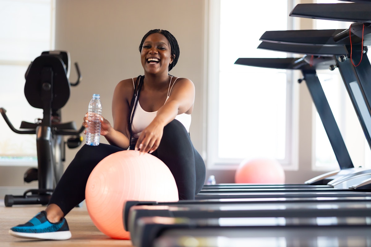 Woman resting after a strength-focused workout in a gym, supporting muscle preservation during weight loss.