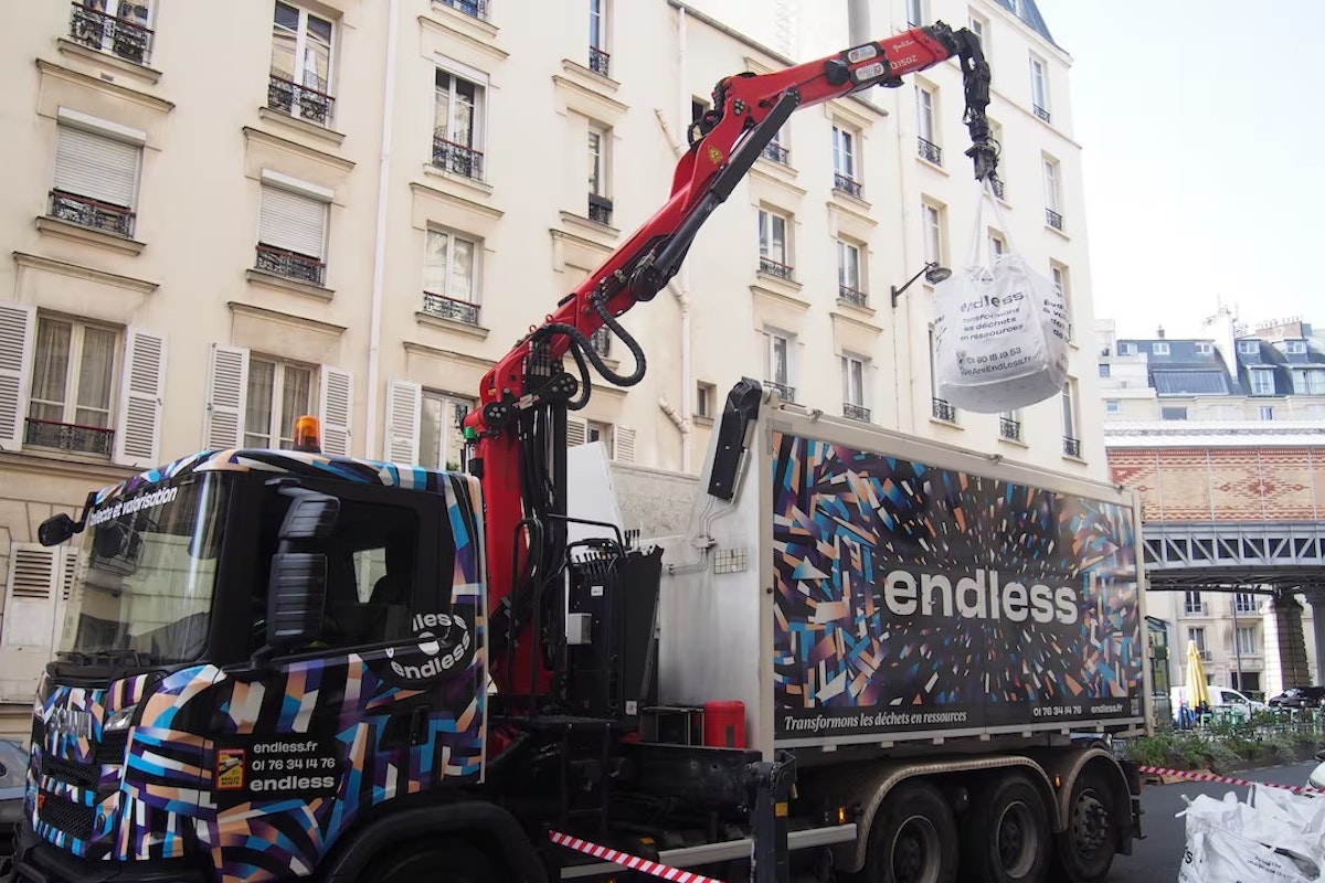 Camion EndLess dans les rues de Paris en train de charger un big bag