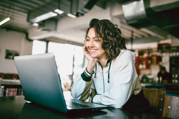 woman at laptop watching video and smiling