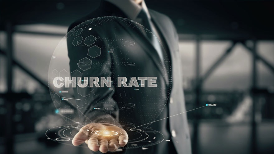business person with hand out with hologram in hand that has a sphere and is labeled "Churn Rate"
