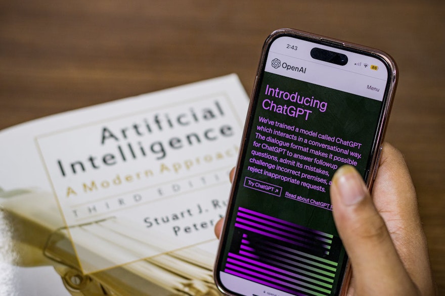 A book on AI with a phone opened on an introduction to ChatGPT
