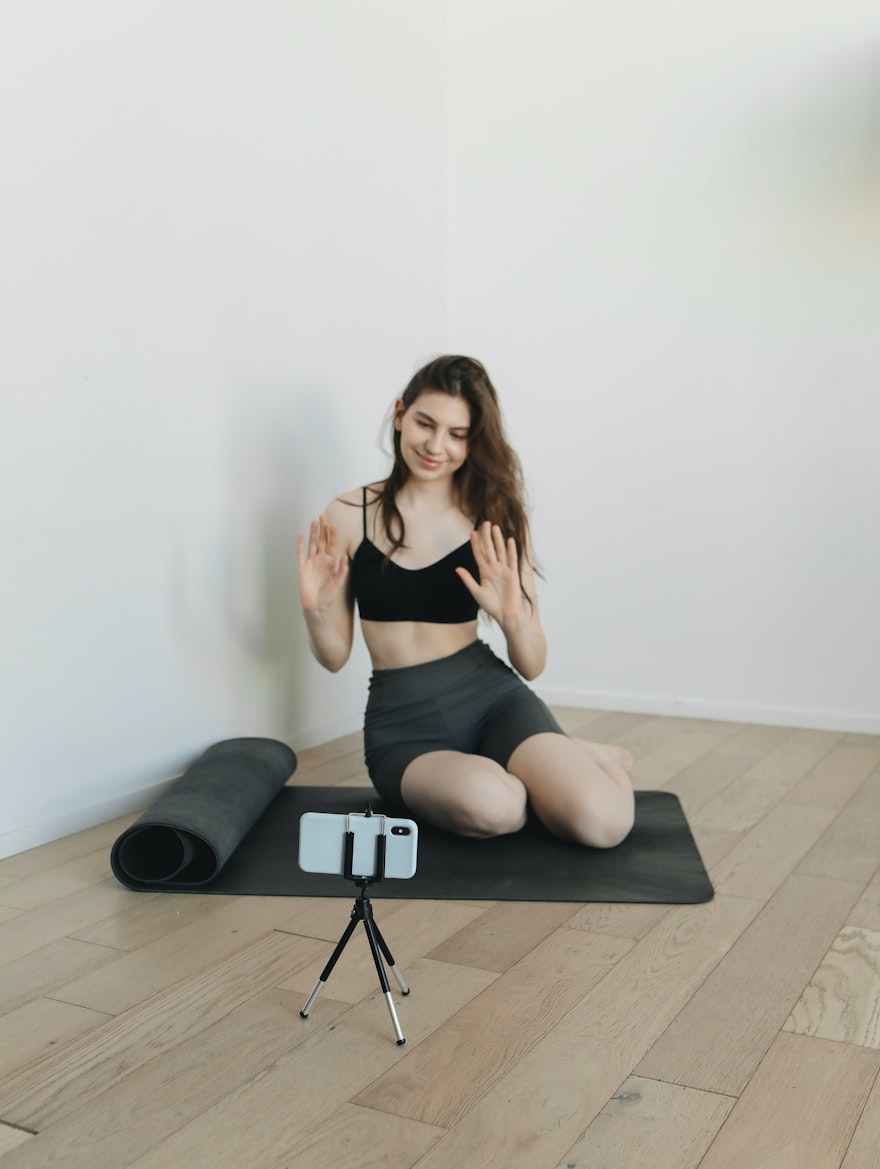 Girl making a yoga video in front of a camera