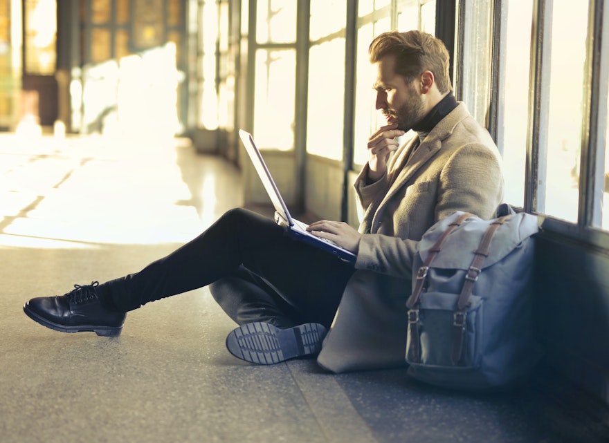 A man working on his laptop in an airport