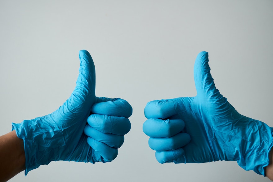 Two gloved hands giving thumbs up