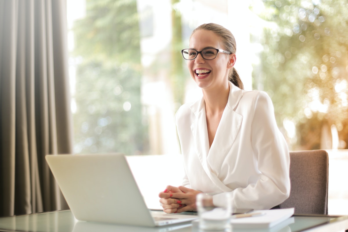 laughing-businesswoman-working-in-office-with-laptop-3756679.jpg